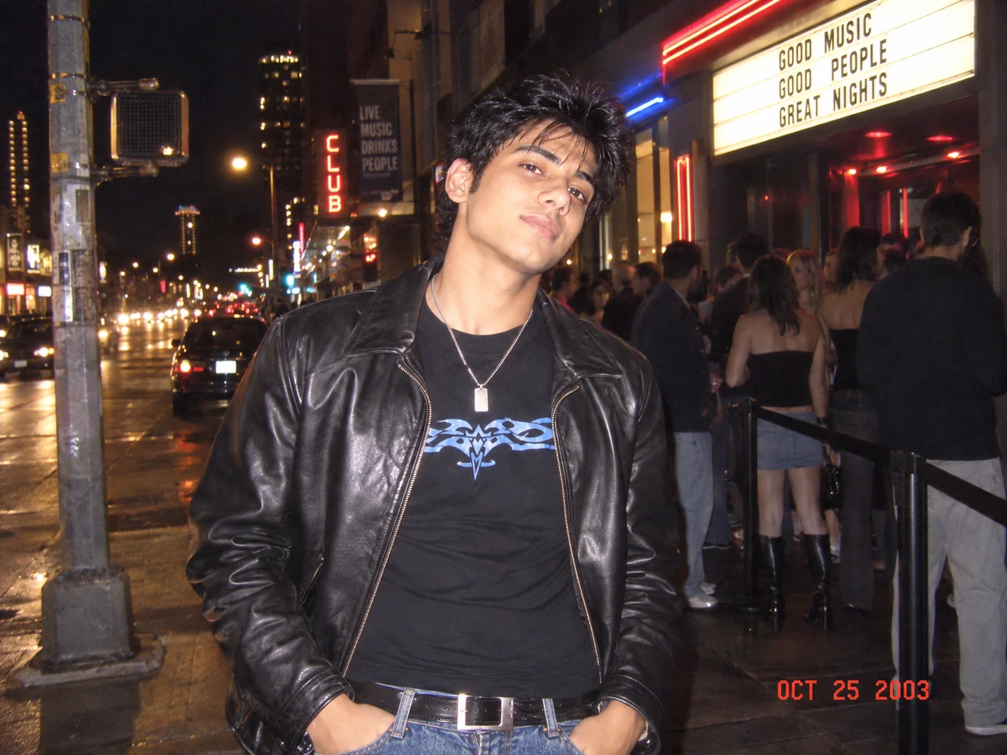 Y2K night-out photo with harsh flash, colorful city lights, and nostalgic digital camera texture